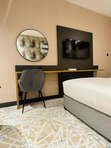 a bedroom with a bed and a mirror and a chair at Sky Park Hotel Deira in Dubai