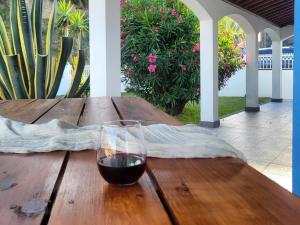 a glass of wine sitting on a wooden table at Oceanview Sunset Retreat in Pilar +64 photos