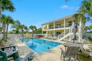 eine Villa mit Swimmingpool und Terrassenmöbeln in der Unterkunft The Yellow House at Herons Walk in Pensacola