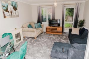 a living room with a couch and a tv at Samuel place in Corby
