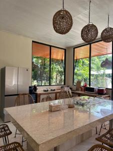 a kitchen with a large island with chairs and windows at Little Bali Villa - Luxury Lake View at Bogor in Kalisuren 2