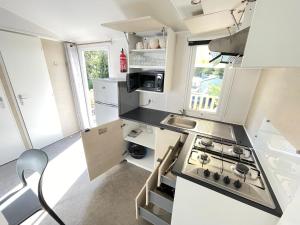 a small kitchen with a stove and a sink at La Loge - E065 - Le Touquet-Paris-Plage in Camiers