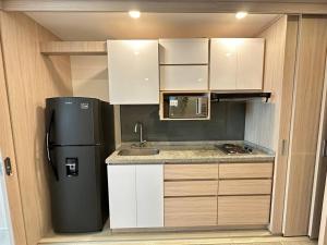 a small kitchen with a refrigerator and a sink at Belmonte205-Apartaestudio en Avenida con piscina, terraza,bbq in Armenia