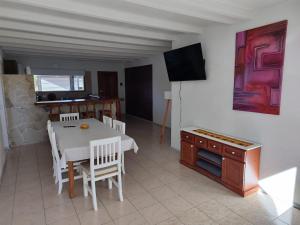 a kitchen and dining room with a white table and chairs at Sol de montaña, Bariloche. in San Carlos de Bariloche