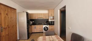 a kitchen with a refrigerator and a table with chairs at Appart à Malaga Beach Mansouria in Mansouria