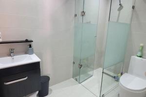 a bathroom with a glass shower and a toilet at Appart à Malaga Beach Mansouria in Mansouria