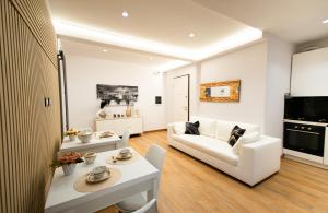 a living room with a white couch and a table at MBS Marconi Bridge Suites Guest House in Rome +51 photos