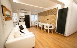 a living room with a white couch and a table and chairs at MBS Marconi Bridge Suites Guest House in Rome
