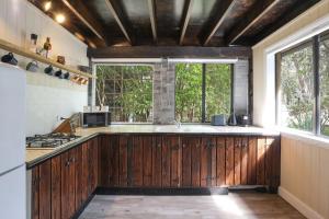 a kitchen with wooden cabinets and a large window at Waterfront Getaway, Pet Friendly & 1 Night Stays! in St Georges Basin