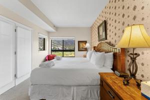 una camera da letto con un grande letto con una lampada e una finestra di Greens at Copper 316 a Copper Mountain
