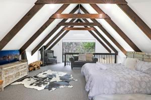 a attic room with a bed and a couch at Waterfront Stay, Pet Friendly 1 Night Stays! in St Georges Basin
