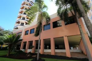 a building with palm trees in front of it at Bonaparte Hotel - Excelente Apartamento #1019 in Brasilia