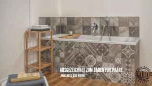 a bathroom with a sink and a tiled wall at HARZER HEALING CENTER 2024 Romantische Landhauswohnung mit Fussbodenheizung,XXL Kochinsel,XXL Regenduschen,Modern,Hochwertig,Persönlich,Vollausgestattet in Elbingerode