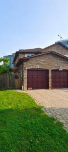 a brick house with two garage doors in a yard at Tom oker in Mississauga