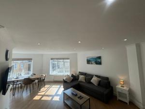 a living room with a black couch and a table at 2 bedroom, Parking, Hounslow St in London