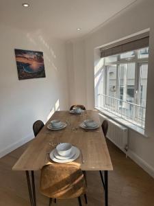 Un comedor con mesa y sillas de madera. en 2 bedroom, Parking, Hounslow St, en Londres