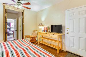 1 dormitorio con 1 cama y escritorio con TV en Garden District Home with Community Perks!, en Tucson