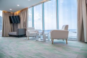 a room with chairs and a tv and windows at Hotel Vip La Guaira in Macuto