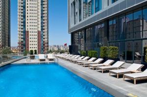 a hotel swimming pool with lounge chairs and buildings at Radisson Blu Hotel Istanbul Asia in Istanbul