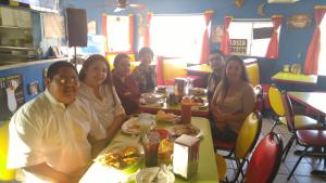 a group of people sitting at a table in a restaurant at Eunice Plaza Motel in El Monte