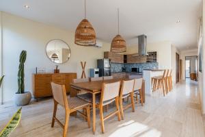 a kitchen and dining room with a wooden table and chairs at Beautiful 3 BDR, 3 BA Modern Condo MINUTES From Beach in Tulum