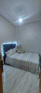 a teddy bear sitting on a bed in a room at Appartement meublé in Ville Nouvelle