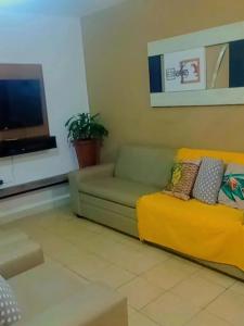 a living room with a couch and a television at AP Ventidor in Guarapari