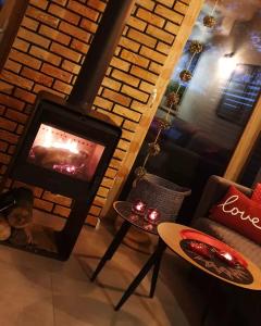 a living room with a fireplace and a chair and a table at Sjesta al mare, domki z sauną i balią z jacuzzi in Lubiatowo