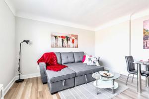 a living room with a gray couch and a table at Modern Apartment in Corktown Hamilton Sleeps 4 in Hamilton