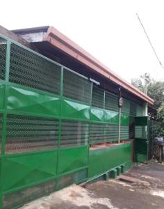 a green fence in front of a building at Alojamiento Juana in Puerto Iguazú
