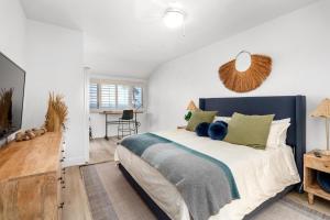 a bedroom with a large bed with green pillows at Pacific Passion Beach House in Carlsbad