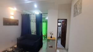 a living room with a blue chair and blue curtains at ResidenceGermanotech VIP 2e, internet 2 balcons internet gardien menagere sur place in Douala +82 photos