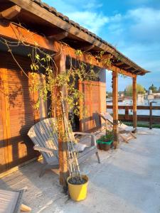 a wooden building with a bench and a tree at La Escondida in San Antonio de Areco