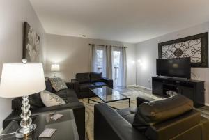 a living room with couches and a flat screen tv at Glam R Us - Pool - Fabulous Location Must Stay in Branson