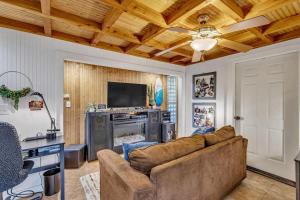 a living room with a couch and a television at Bare Feet Bunkhouse-Close to beach & dog friendly in Gulfport