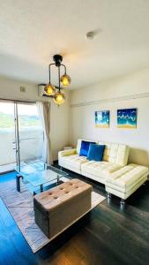 a living room with two couches and a glass table at ocean terrace SESOKO 301 in Ufugumui