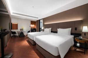 Postel nebo postele na pokoji v ubytování Intercity Shanghai Xujiahui - Free Minibar and near Yishan Road Metro Station