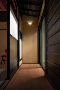un couloir d'une maison avec une porte et des fenêtres dans l'établissement Tsuyukusa-an, à Kyoto