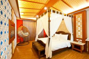 una camera con letto a baldacchino e panca di Yudali Motel a Donggang