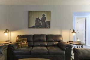 a living room with a brown couch and two tables at Western Comfort in Branson
