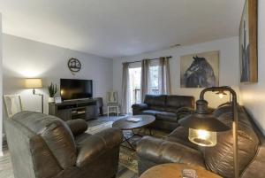 a living room with leather furniture and a television at Western Comfort in Branson +24 photos