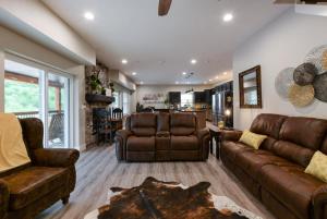 a living room with two brown leather couches and a table at Livin' The Dream- Indoor Outdoor pool & Private Hot Tub in Branson