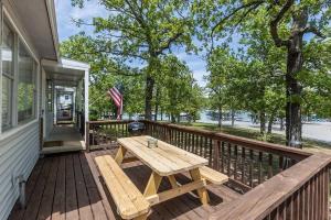 a wooden deck with a picnic table on a house at Wake Zone Lighthouse Lodge - Lake Views in Kimberling City