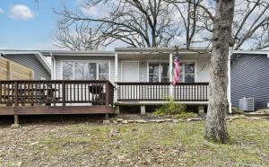 a house with a porch with a flag on it at Wake Zone Lighthouse Lodge - Lake Views in Kimberling City +37 photos