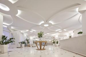 Habitación blanca con mesa y macetas en Santorini Palace, en Fira