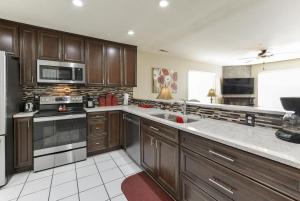 a kitchen with wooden cabinets and a stove top oven at Little House on the Fairway- Luxury Golf Condo in Branson