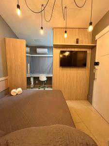 a bedroom with a bed and a flat screen tv at Cine Rio Hostel RJ in Rio de Janeiro