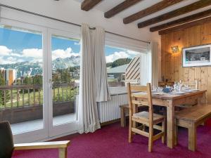 une salle à manger avec une table et une grande fenêtre dans l'établissement Duplex cosy à Courchevel 1850, 6-8 pers, proche pistes - FR-1-631-218, à Courchevel