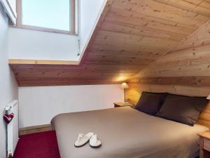 une chambre avec un lit avec des chaussures dessus dans l'établissement Duplex cosy à Courchevel 1850, 6-8 pers, proche pistes - FR-1-631-218, à Courchevel 1 autre photo