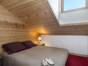 une chambre avec un lit avec une fenêtre et des chaussures dans l'établissement Duplex cosy à Courchevel 1850, 6-8 pers, proche pistes - FR-1-631-218, à Courchevel
